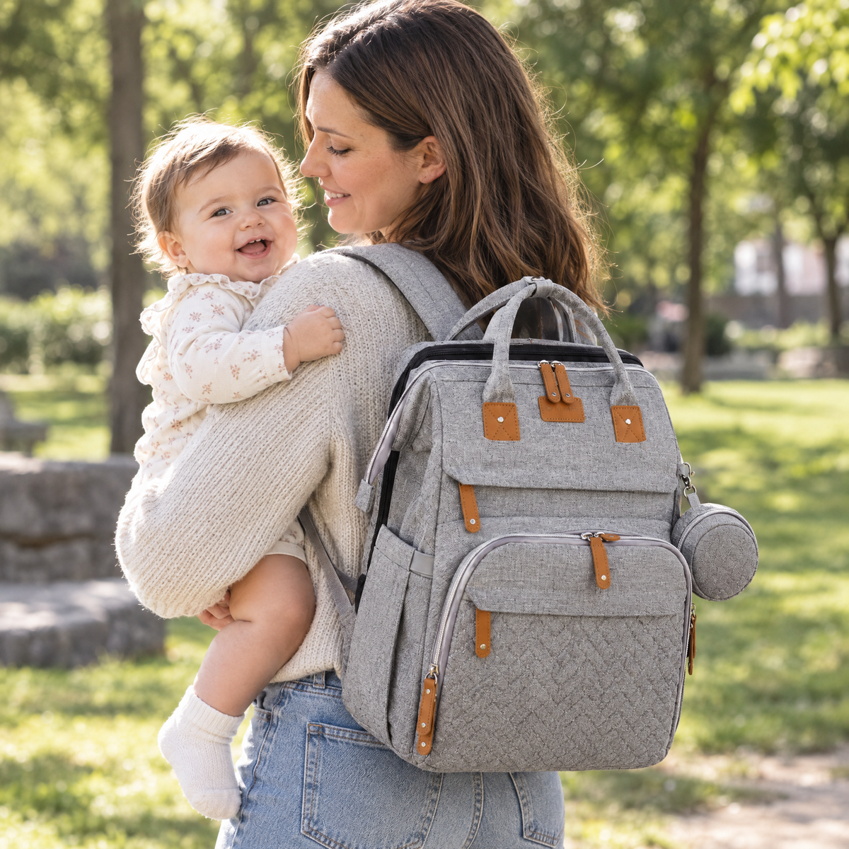 Mutter mit Baby und SnoozePack Wickelrucksack im Park